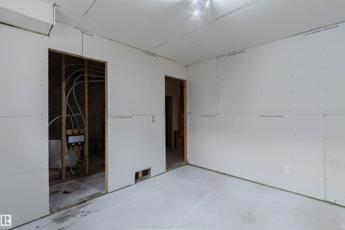 Unfinished interior space featuring drywall installation and visible plumbing rough-ins - 6717 Elston Lane Nw, Edmonton, AB - Indoor Photo Showing Garage
