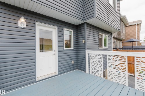 Upper-level deck featuring blue-grey wood-finish flooring and decorative white railings - 6717 Elston Lane Nw, Edmonton, AB - Outdoor