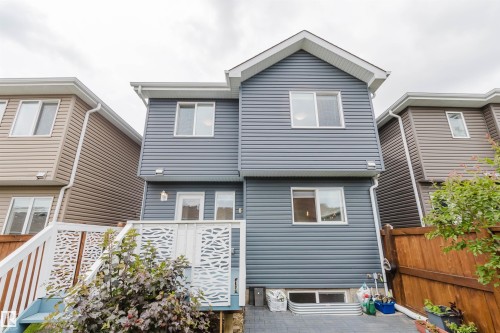 Multi-level rear exterior featuring blue horizontal siding and white trim - 6717 Elston Lane Nw, Edmonton, AB - Outdoor With Exterior