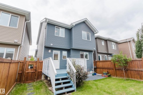 Rear exterior featuring blue siding, white trim, and multiple windows - 6717 Elston Lane Nw, Edmonton, AB - Outdoor