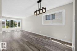 Spacious room featuring wood-finish flooring, light grey walls, and white trim - 