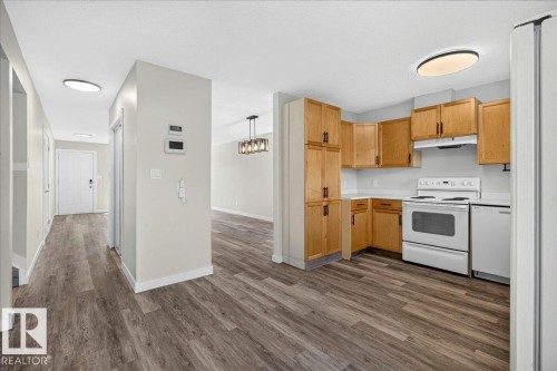 Kitchen featuring wood cabinetry, white appliances, and light countertops - 4212 32 Avenue Nw, Edmonton, AB - Indoor Photo Showing Kitchen