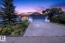 Single-story residence featuring a two-car garage with a blue door, a concrete driveway, and a front yard with mature landscaping - 4212 32 Avenue Nw, Edmonton, AB  - Outdoor With Facade 