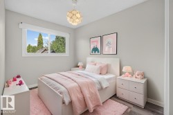 Bedroom featuring light gray walls, wood-finish flooring, a white window frame with a roller blind, and a contemporary ceiling light fixture - 
