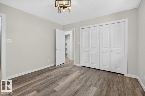 Room featuring wood-finish flooring, light neutral wall paint, and white baseboards - 4212 32 Avenue Nw, Edmonton, AB - Indoor Photo Showing Other Room
