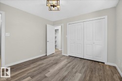 Room featuring wood-finish flooring, light neutral wall paint, and white baseboards - 