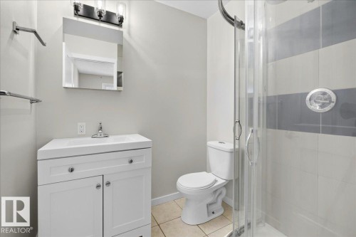 Full bathroom featuring a white vanity with integrated sink, chrome faucet, and rectangular mirror - 4212 32 Avenue Nw, Edmonton, AB - Indoor Photo Showing Bathroom
