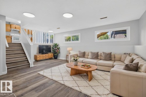 Spacious living area featuring wood-finish flooring, multiple windows, and recessed lighting - 4212 32 Avenue Nw, Edmonton, AB - Indoor Photo Showing Living Room