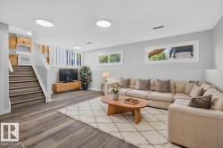 Spacious living area featuring wood-finish flooring, multiple windows, and recessed lighting - 