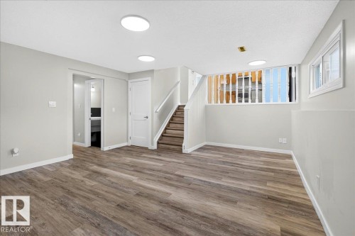 Spacious room with wood-finish flooring, light grey walls, and recessed ceiling lighting - 4212 32 Avenue Nw, Edmonton, AB - Indoor Photo Showing Other Room
