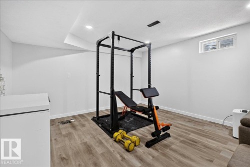 Finished basement room featuring wood-finish flooring, recessed lighting, and a window - 4212 32 Avenue Nw, Edmonton, AB - Indoor Photo Showing Gym Room
