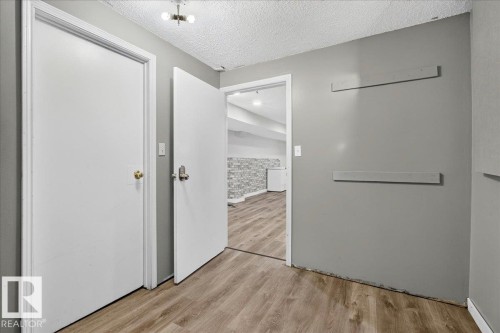 Interior space featuring wood-finish flooring, light gray walls, and white trim - 4212 32 Avenue Nw, Edmonton, AB - Indoor Photo Showing Other Room