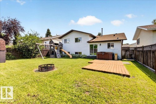 Expansive backyard featuring a lush lawn, a fire pit, and a wooden deck - 4212 32 Avenue Nw, Edmonton, AB - Outdoor