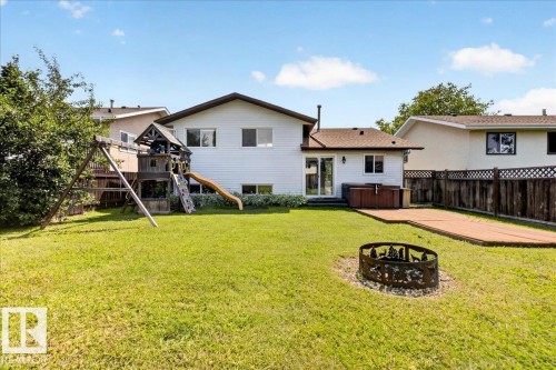 Expansive backyard featuring a green lawn, wood fence perimeter, and a fire pit - 4212 32 Avenue Nw, Edmonton, AB - Outdoor