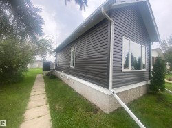 Modern siding in a dark finish complemented by white window frames - 