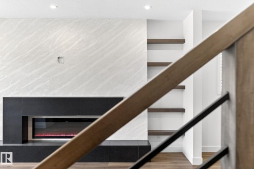 Contemporary fireplace with a black surround and linear firebox, set against a patterned wall finish - 5308 103A Avenue, Edmonton, AB - Indoor Photo Showing Other Room With Fireplace