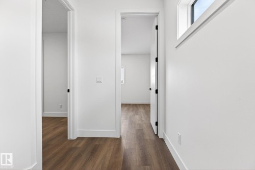 Hallway featuring wood-finish flooring, white trim, and white walls - 5308 103A Avenue, Edmonton, AB - Indoor Photo Showing Other Room