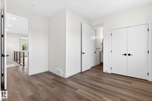 Wood-finish flooring throughout, complemented by white trim and neutral wall tones - 5308 103A Avenue, Edmonton, AB - Indoor Photo Showing Other Room