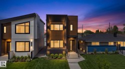 Modern two-story facade featuring dark-framed windows, a flat roofline, vertical panel siding, exterior wall sconces, and a neatly manicured lawn - 