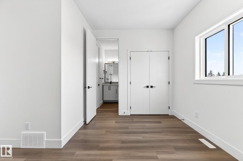Open room featuring wood-finish flooring, white walls, and a white window frame - 5308 103A Avenue, Edmonton, AB - Indoor Photo Showing Other Room