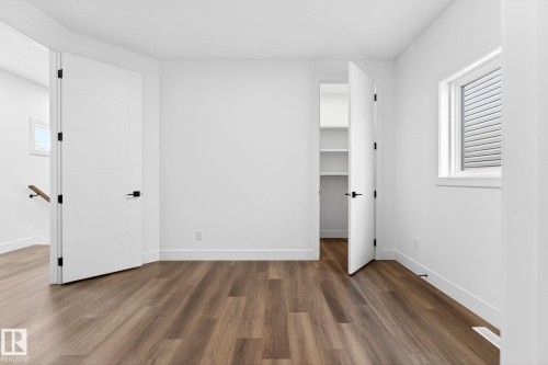 Bright room featuring wood-finish flooring, white walls, and a window with horizontal blinds - 5308 103A Avenue, Edmonton, AB - Indoor Photo Showing Other Room