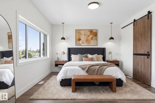 Bedroom featuring wood-finish flooring, a contemporary ceiling light fixture, and a large window - 5308 103A Avenue, Edmonton, AB - Indoor Photo Showing Bedroom
