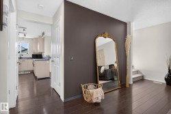 Dark wood-finish flooring extending through the entry and into the kitchen - 