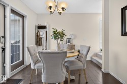 Dining area featuring dark wood-finish flooring, neutral wall paint, and a multi-bulb chandelier - 