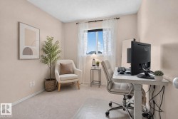 Neutral-toned room featuring light-colored carpeting and pale walls - 