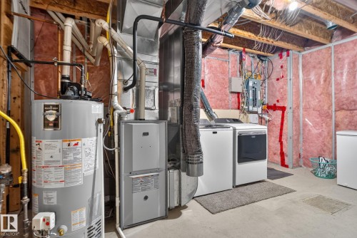 Utility area featuring a water heater, furnace, and laundry appliances with exposed ceiling joists and wall insulation - 191 Brookview Place, Stony Plain, AB - Indoor Photo Showing Basement