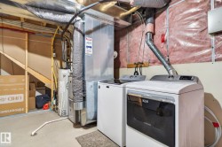Laundry area featuring a side-by-side washer and dryer, adjacent to a furnace and water heater - 