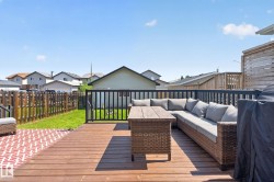 Spacious wooden deck featuring a perimeter railing, offering an elevated outdoor living area - 