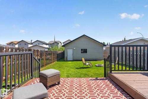 Spacious backyard with a deck featuring dark railings, a detached garage, and a privacy fence - 191 Brookview Place, Stony Plain, AB - Outdoor With Exterior