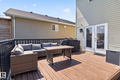 Spacious wood-finish deck with black metal railings, offering direct access to the interior via double French doors - 191 Brookview Place, Stony Plain, AB - Outdoor With Deck Patio Veranda With Exterior