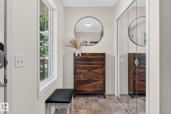 Entryway featuring neutral wall paint, a grid-pane window, and square tile flooring - 