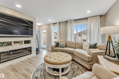 Living area featuring wood-finish flooring and recessed lighting - #25 1530 Tamarack Bv Nw, Edmonton, AB - Indoor Photo Showing Living Room With Fireplace