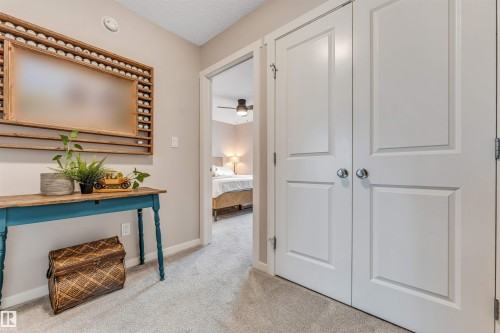 Light grey wall color throughout the hallway and into the open doorway - #25 1530 Tamarack Bv Nw, Edmonton, AB - Indoor Photo Showing Other Room