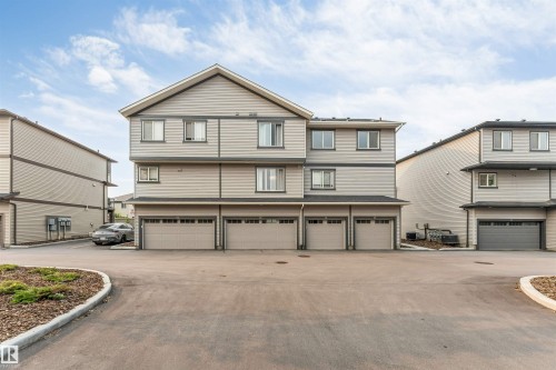 Multi-level residential building featuring light gray siding and dark trim - #25 1530 Tamarack Bv Nw, Edmonton, AB - Outdoor