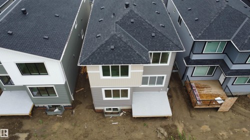 Multi-story residence featuring a dark shingle roof and multiple windows - 8423 Mayday Link Link Sw, Edmonton, AB - Outdoor