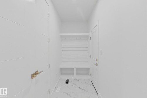 Entryway featuring built-in storage with hooks and bench seating - 8423 Mayday Link Link Sw, Edmonton, AB - 