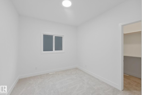 Room featuring light gray carpet flooring, white walls, a single window, recessed ceiling lighting, and an open closet with shelving - 8423 Mayday Link Link Sw, Edmonton, AB - Indoor Photo Showing Other Room