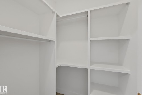 White built-in shelving system featuring multiple storage compartments and a hanging rod - 8423 Mayday Link Link Sw, Edmonton, AB - Indoor With Storage