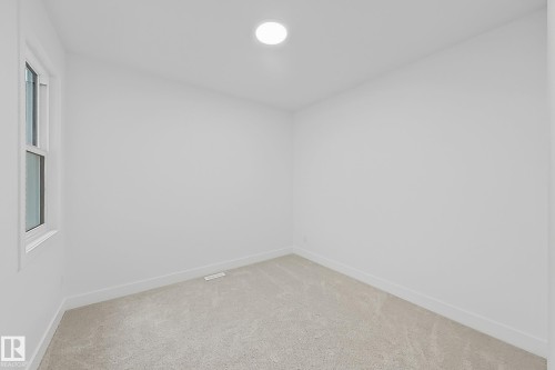 Neutral-toned carpeting, white walls, and a recessed ceiling light illuminate this room - 8423 Mayday Link Link Sw, Edmonton, AB - Indoor Photo Showing Other Room