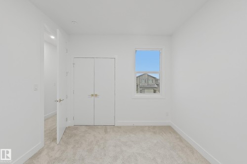 Light-toned wall-to-wall carpeting complements the white walls and trim - 8423 Mayday Link Link Sw, Edmonton, AB - Indoor Photo Showing Other Room