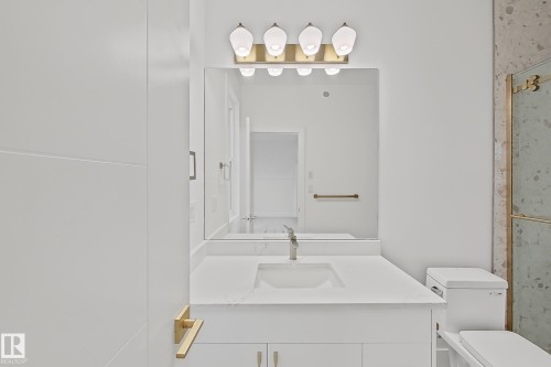 Bathroom featuring a white vanity with an integrated sink, polished chrome faucet, and a large mirror - 8423 Mayday Link Link Sw, Edmonton, AB - Indoor Photo Showing Other Room