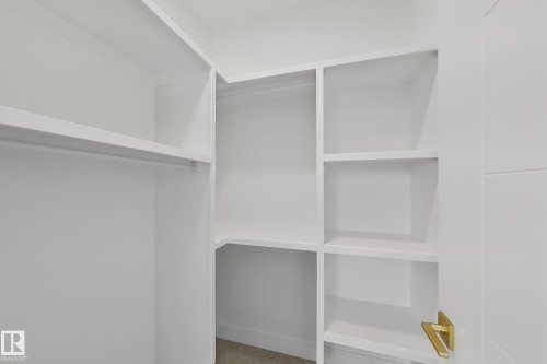 Custom white built-in shelving with multiple storage levels and hanging rod - 8423 Mayday Link Link Sw, Edmonton, AB - Indoor With Storage