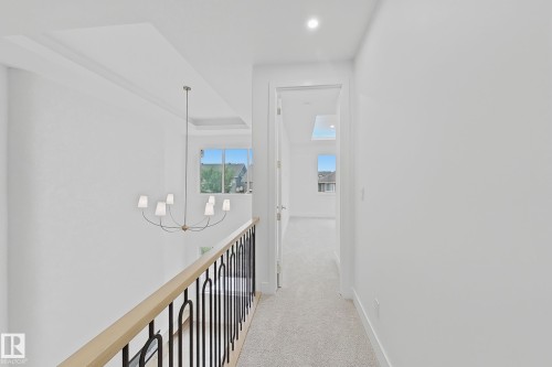 Upper-level hallway with carpet flooring, recessed lighting, and a contemporary chandelier - 8423 Mayday Link Link Sw, Edmonton, AB - Indoor Photo Showing Other Room