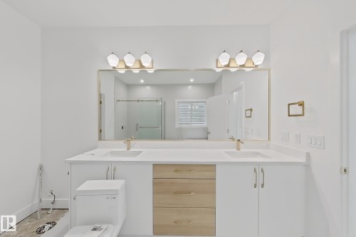 Dual vanity featuring white cabinetry, light wood-finish drawers, and a light-toned countertop - 8423 Mayday Link Link Sw, Edmonton, AB - Indoor Photo Showing Bathroom