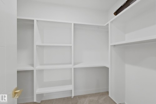 Custom closet system featuring white shelving and hanging rods - 8423 Mayday Link Link Sw, Edmonton, AB - Indoor With Storage