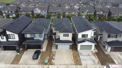 Newly constructed residence featuring a contemporary exterior with contrasting siding, black asphalt shingle roof, and an attached garage - 8423 Mayday Link Link Sw, Edmonton, AB - 